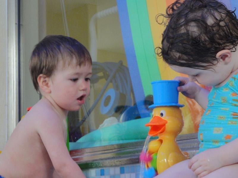 Zwei Kinder spielen mit Enten-Spielzeug