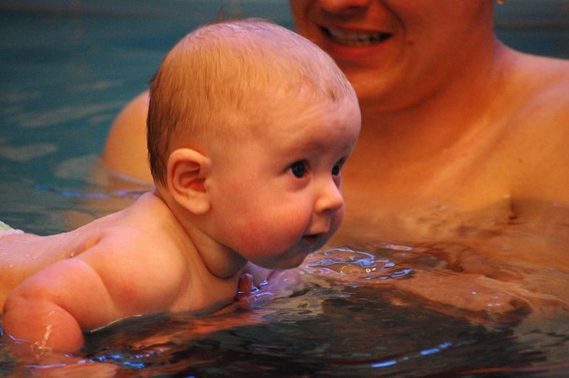 Baby schwimmt entspannt im Becken