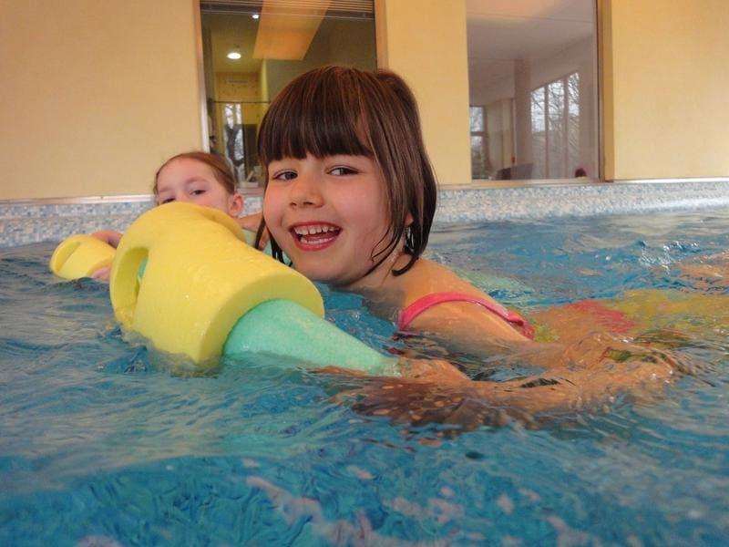 Mädchen schwimmt mit Schwimmnudel