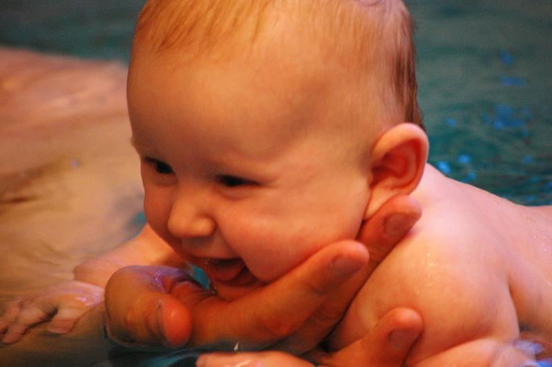 Lachendes Baby beim Babyschwimmen