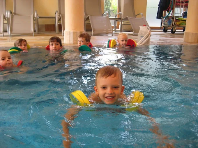 Kindergruppe schwimmt zusammen im Becken
