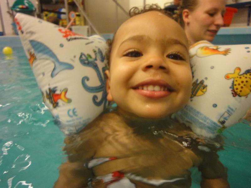 Strahlendes Kleinkind mit Schwimmflügeln