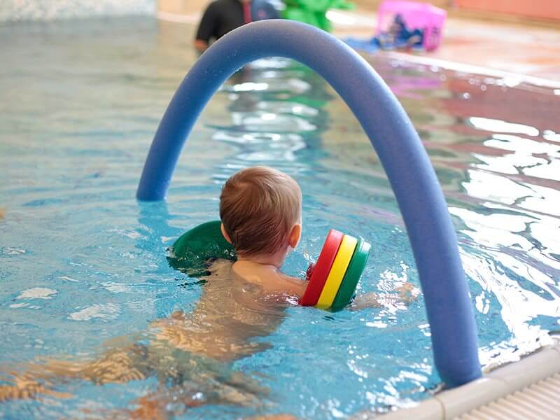 Kind beim Schwimmen mit Poolnudel